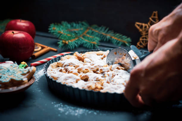 Man cutting Apple pie on a festive table decorated for Christmas
