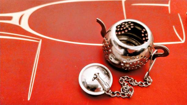 Traditional cast iron asian teapot with clay cup on red background
