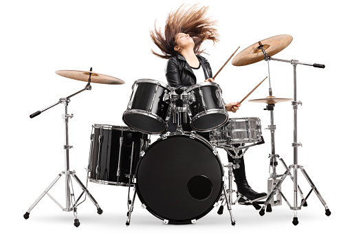 Energetic female drummer throwing her hair and playing drums isolated on white background