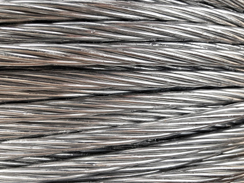 Close up of coiled metal cable industrial background.