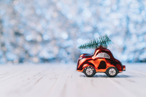 istock Little red toy car carries a Christmas tree 1193707198