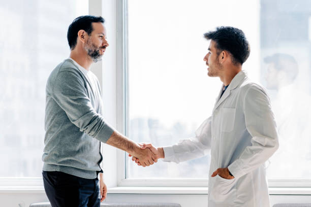 patient handshaking with doctor in hospital - doctor patient greeting talking imagens e fotografias de stock