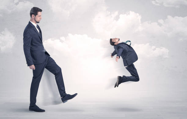 istock Big boss kicking little employee 1193707811