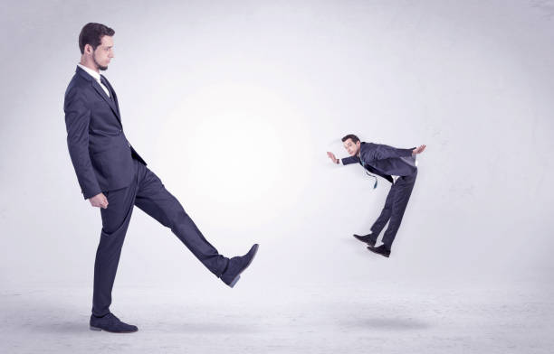 istock Big man kicking little himself out 1193707853