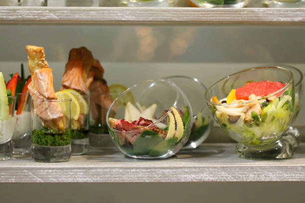 Snacks at the stand-up party or buffet lunch. Seafood, vegetables, fruit in bowls and glasses. Tasty food treats on the table. Catering service.