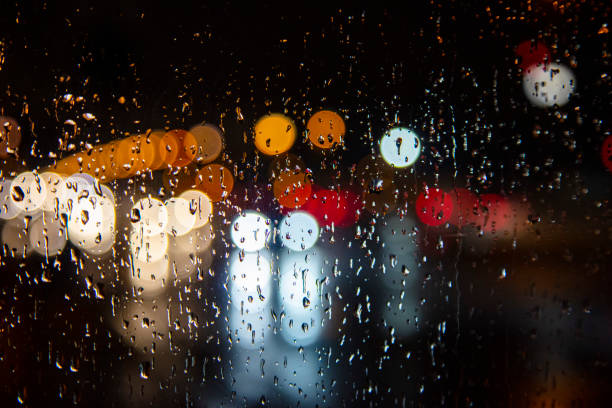 istock rain drops in the window surface and traffic bokeh 1193708988