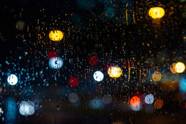 rain drops in the window surface and traffic bokeh