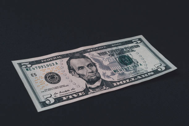 istock On the black background is one bill in size five dollars. 1193709348