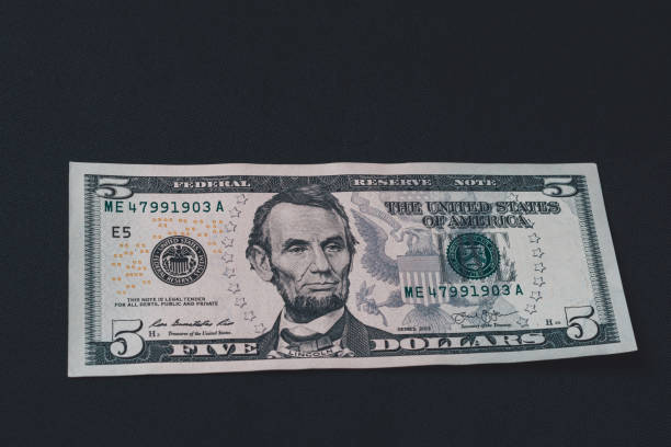 istock On the black background is one bill in size five dollars. 1193709364