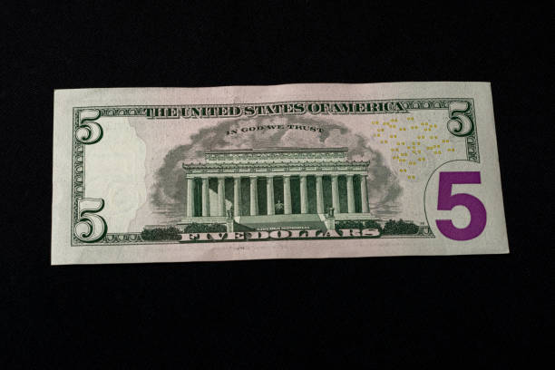 istock The American five dollars lie on the back on a black background. 1193709893