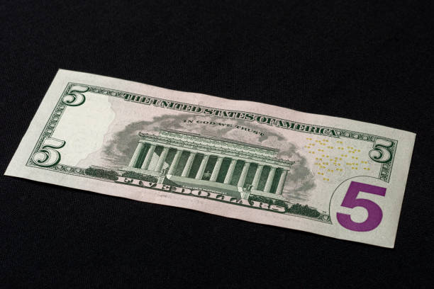 istock The American five dollars lie on the back on a black background. 1193709895