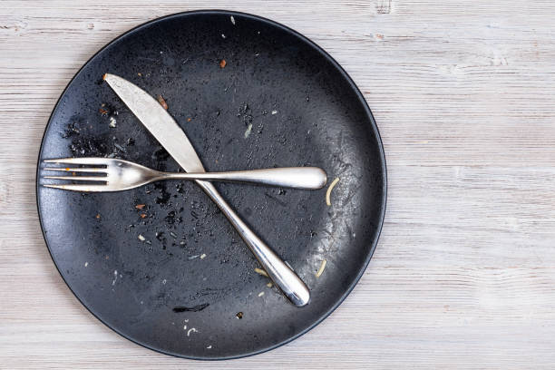 istock crossed knife and fork on plate on gray table 1193710567