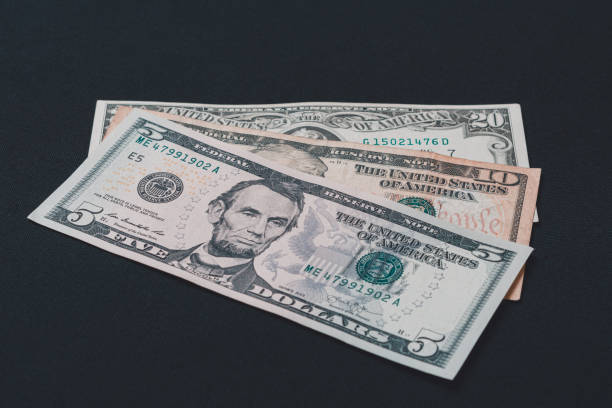 istock Five, ten and twenty dollar bills lie on a black background. 1193711441