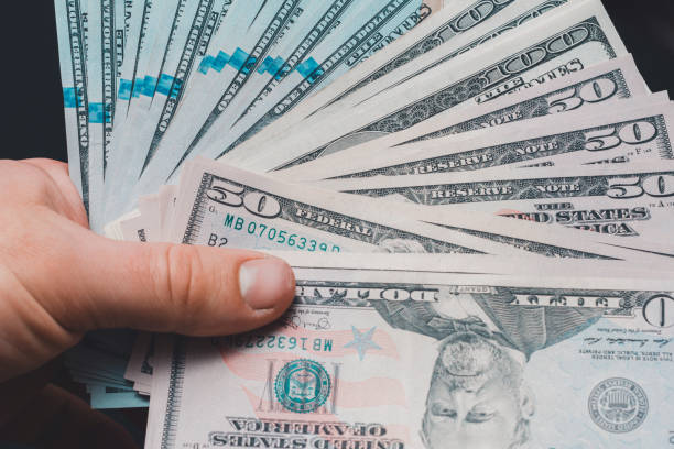 istock Composition of all US dollar notes stacked on a black background with space for copying. 1193711479