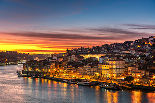 View to Porto over river Douro with reflection of the lights at sunset