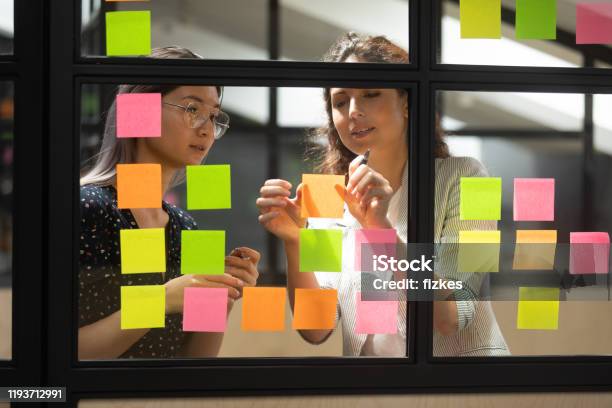 Two Multiracial Female Partners Planning Business Project Stock Photo - Download Image Now