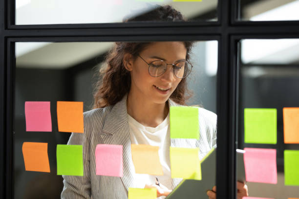 istock Smiling smart businesswoman using kanban agile scrum method glass board. 1193712996