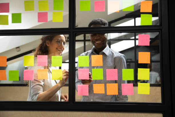 istock Happy mixed race colleagues standing near window glass board. 1193713009