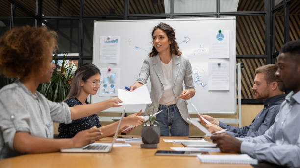 istock Business people group looking through project results at meeting. 1193713041
