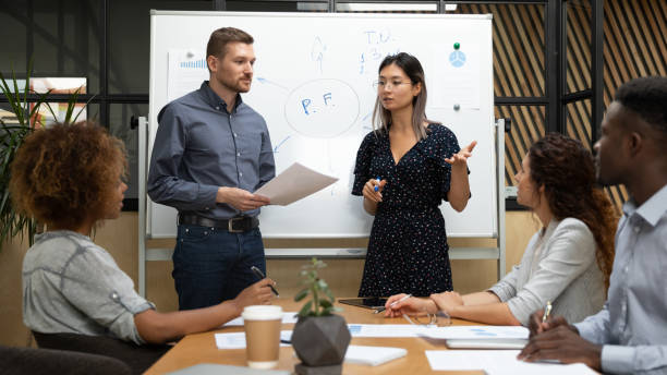 istock Concentrated speakers presenting project to diverse colleagues. 1193713056