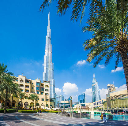 Dubai, UAE - December 6. 2019 - the shiny Burj Khalifa in Dubai is currently the tallest building in the world and one of the most photographed. In front of the Burj is a beautiful artificial lake with a fountain and the Dubai Mall. Many tourists visit this attraction every day.