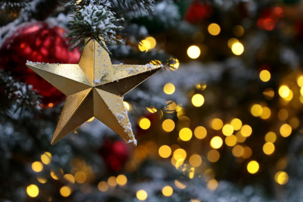 istock Christmas star on a fir branches on festive golden lights background, night illumination 1193717708