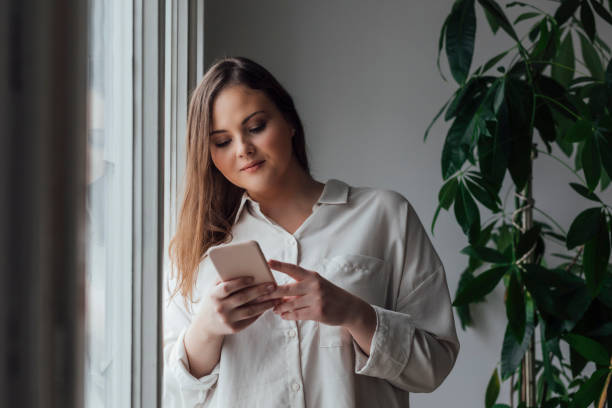 istock Pretty Plus Size Woman Using her Cell Phone 1193720710