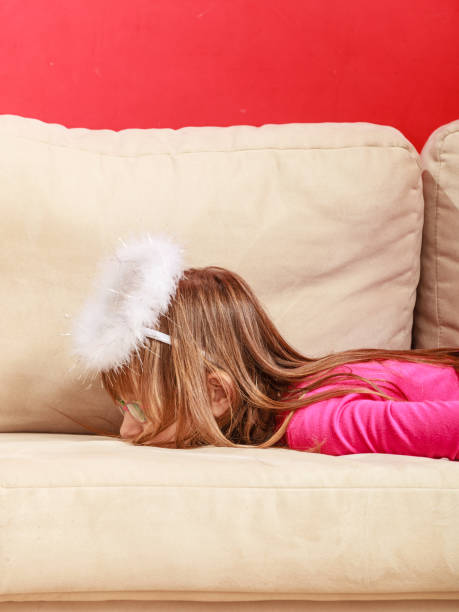 istock Bored girl dressed as an angel lying on sofa 1193721013