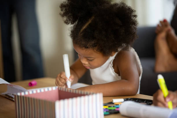 istock Cute Girl Drawing While Sitting At Table 1193722615