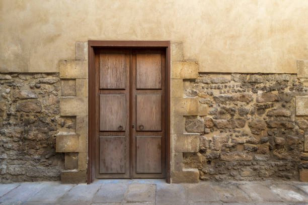 istock Grunge wooden aged door on grunge stone bricks wall 1193724082