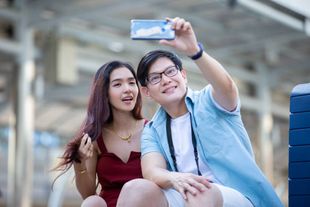 istock Couple Taking Selfie While Sitting In City 1193725424