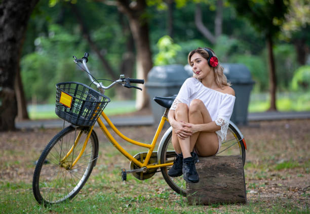 istock Young Woman Sitting By Bicycle In Park 1193725629
