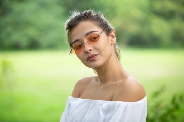 istock Young Woman Wearing Sunglasses Standing In Park 1193725665