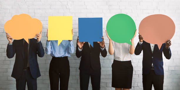 Group of corporate people hiding faces behind speech bubbles Business opinion concept. Group of corporate people hiding faces behind blank speech bubbles, empty space debate stock pictures, royalty-free photos & images