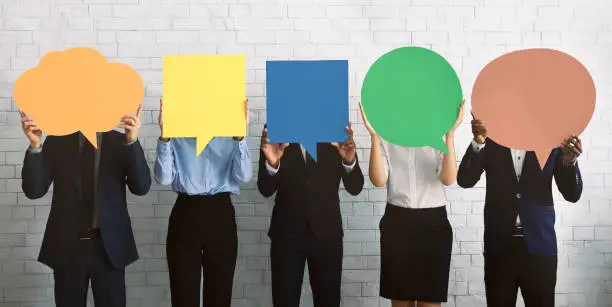 Business opinion concept. Group of corporate people hiding faces behind blank speech bubbles, empty space