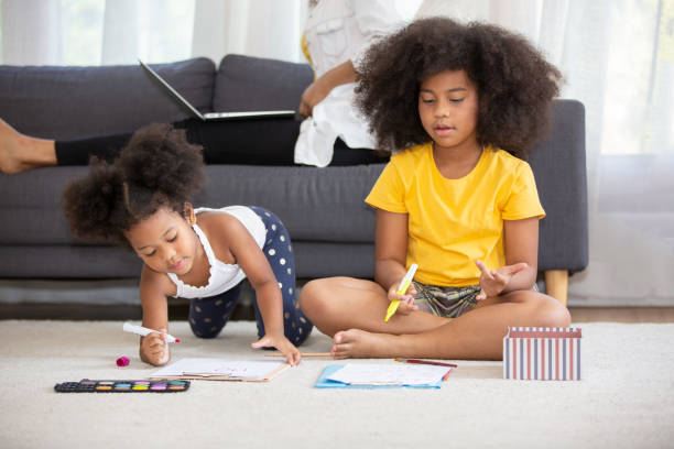 istock Siblings Drawing While Sitting On Rug At Home 1193725915