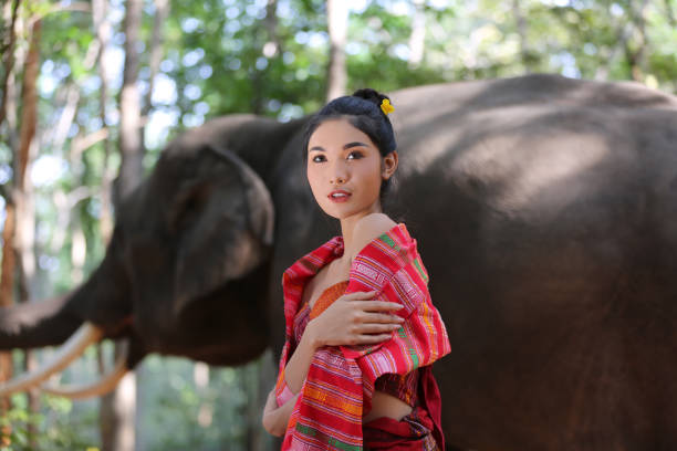istock Thoughtful Woman Looking Away While Standing Against Elephant 1193726054