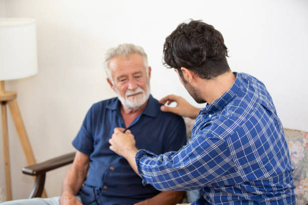 istock Man Looking At Father Sitting On Sofa At Home 1193728389