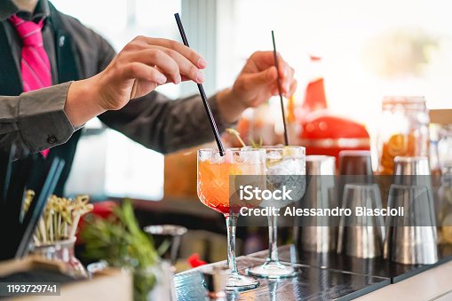 istock Young bartender making cocktails at bar counter - Barman serving drinks - Work, passion and mixologist concept 1193729741