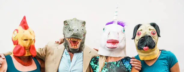 Photo of Happy family wearing different carnival masks - Crazy people having fun wearing on chicken, t-rex and unicorn mask - Concept of bizarre, humor and masquerade holidays lifestyle party