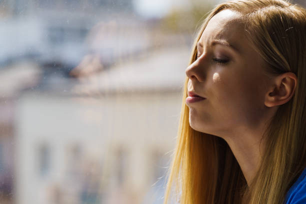 istock Woman relaxing on windowsill 1193729964