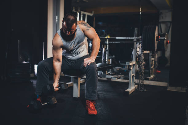 istock Man exercising with dumbbell in gym 1193730672
