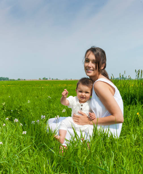 мать и девочка на весеннем лугу - babies and children cheerful low angle view vertical стоковые фото и изображения