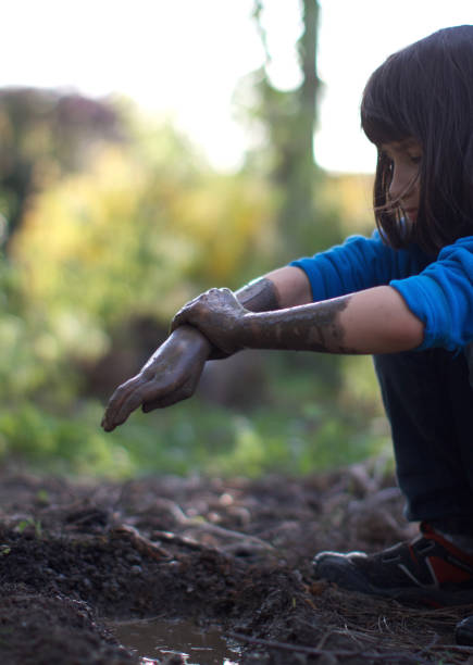 istock Happy grounded child playing outdoor with mud, learning about environment 1193731116