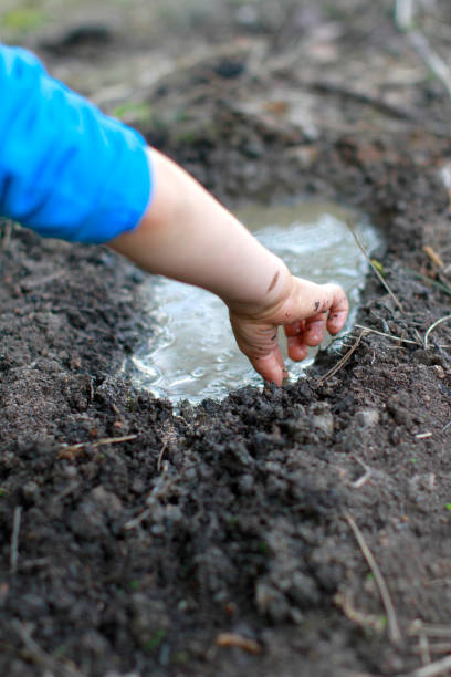 istock Anonymous child arms and hands playing with mud and water 1193731755