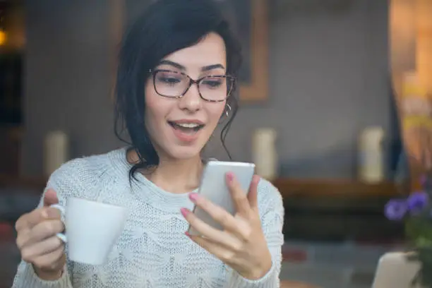 Photo of Amazed woman checking phone finding good news