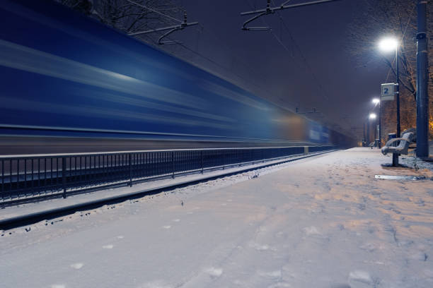 istock Passing freight train in blurred motion at train station on a winter night 1193734636