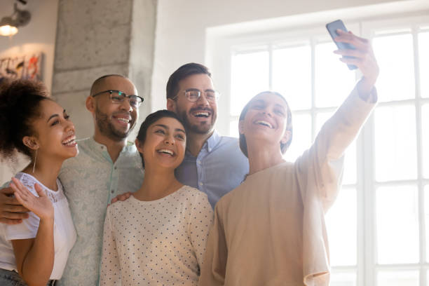 istock Group of laughing students having fun together, recording funny video. 1193735010