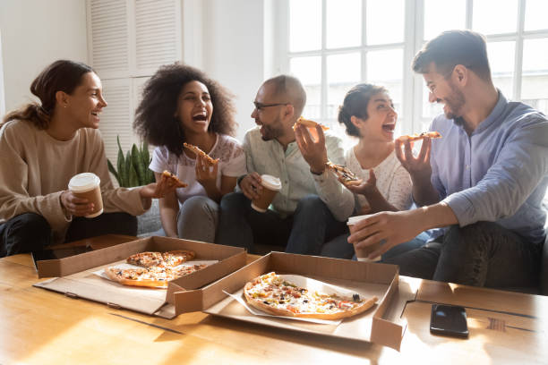 istock Happy mixed race young colleagues enjoying eating ordered pizza. 1193735034