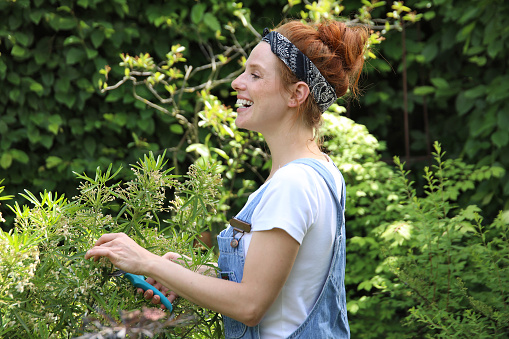 Red-haired woman with dungarees gardening